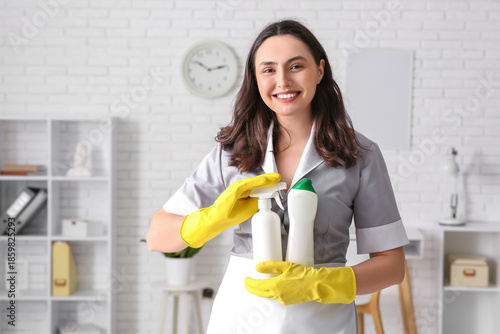 Young chambermaid with bott...