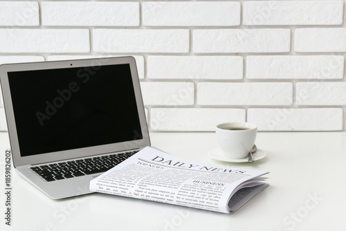 Daily newspaper with laptop...