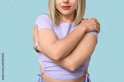 Young woman hugging herself...