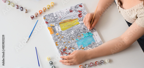 Young woman painting by num...