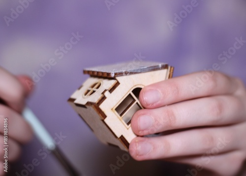 Little wooden house which is painted with white by human female hands decoration festive 