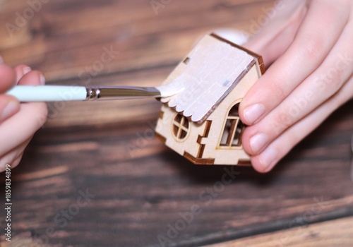 Little wooden house which is painted with white by human female hands decoration festive 