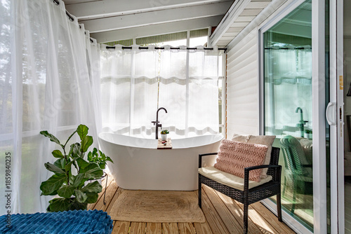 Foto Bright spa style bathroom with freestanding bathtub, sheer curtains and natural