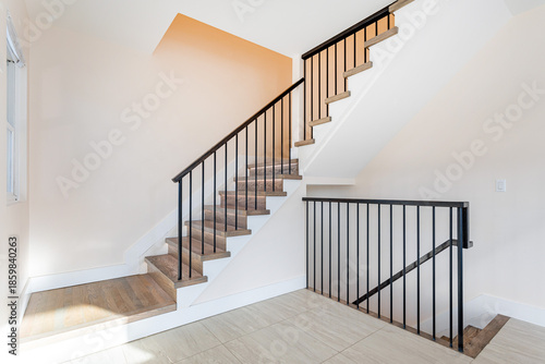 Εκτύπωση καμβά Modern interior staircase with wooden steps and black metal railing in bright mi