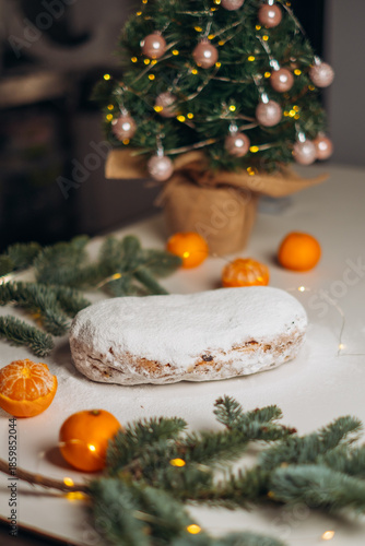 Traditional German Christmas stollen is dusted with powdered sugar through a sieve. The atmosphere is cozy, festive, and warm