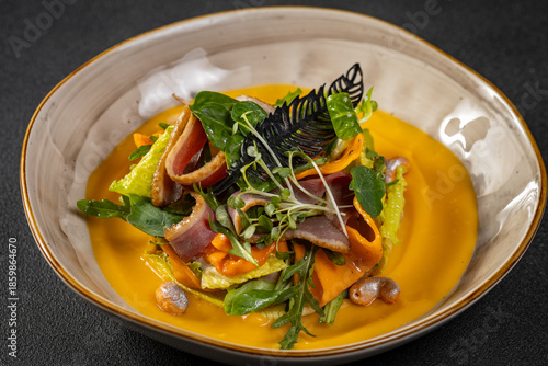 Pumpkin salad with dried duck, cherry tomatoes and pumpkin seeds. Close-up, selective focus