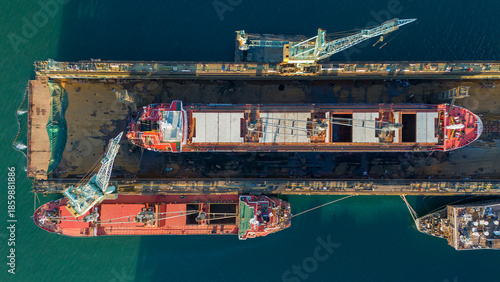Fotografija Overhead drone view of a cargo ship in a floating dry dock with its hatches open