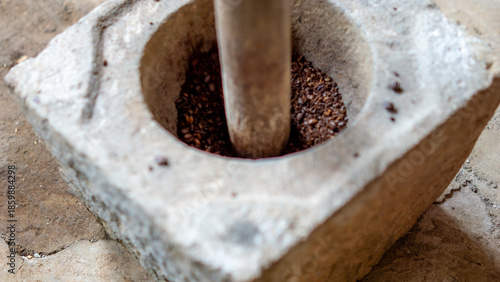 Grinding coffee in the traditional way using a stove made of stone (Indonesians call it lumpang)