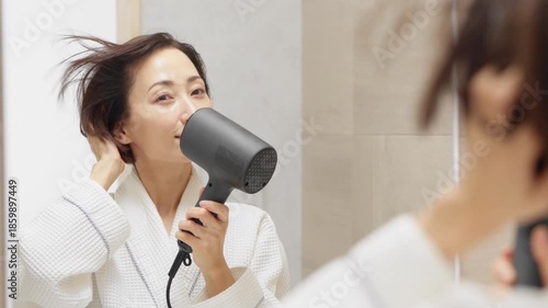 ドライヤーで髪を乾かしている女性　ビューティイメージ