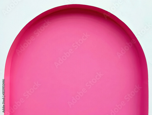 Bright pink archway against a white wall creating a modern minimalist aesthetic