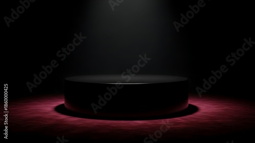 A dimly lit stage with a spotlight illuminating a black podium, casting a reddish glow from below, suggesting an award ceremony or presentation