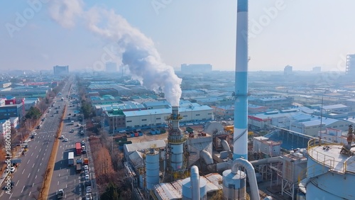smoking chimney and busy road traffic in urban area, showcasing manufacturing, energy production, and environmental impact.