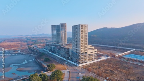 Unfinished high-rise buildings, construction halted by financial deficit, revealing urban development stagnation and economic challenges.