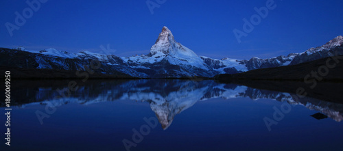 Famos Swiss mountain Matterhorn mirroring in Lake Stelli at the blue hour.