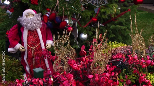 Santa Claus Figure and Decorations in Front of Decorated Christmas Tree