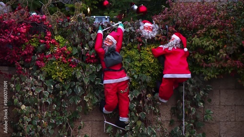 Two Santa Claus Figures Climbing on House Wall Decoration