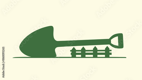 Green silhouette of a garden shovel lying on the ground next to a small wooden fence