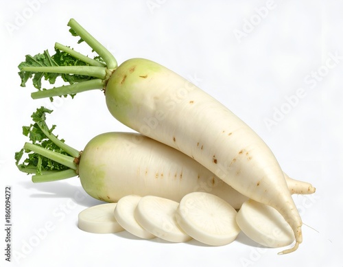 Two white root vegetables with green tops and sliced pieces, isolated