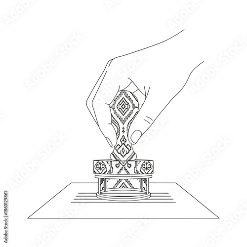 Hand pressing a decorative stamp with intricate patterns.