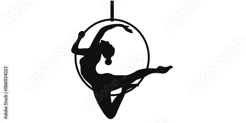 Silhouette of aerial dancer performing acrobatic move on aerial hoop