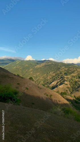 Mount Uwentumbu in Palu, Central Sulawesi, at sunset. Beautiful golden hour landscape featuring rolling hills and green valleys under a clear blue sky. Ideal for nature travel reels.