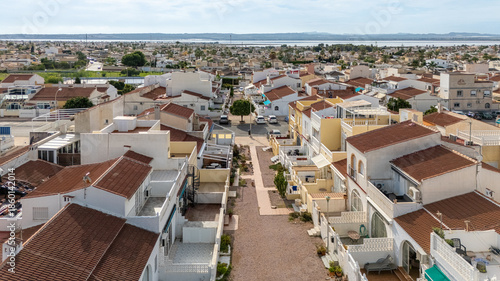 Elevated view of residential neighborhood with tiled rooftops and distant salt lake