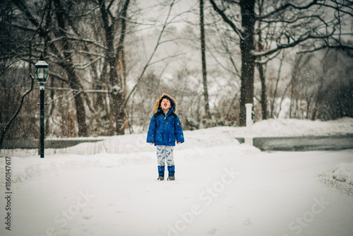 Young boy catching snowflakes during winter wonderland playtime
