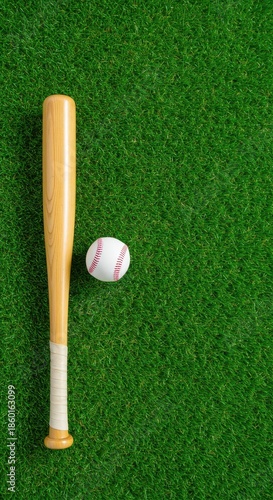 A wooden baseball bat and a white stitched ball are perfectly positioned on a lush, bright green expanse of freshly mown grass, ready for outdoor summer sports ,turf ,play ,preparation