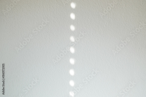 Empty white cement wall room interior background with circle shadow from window.