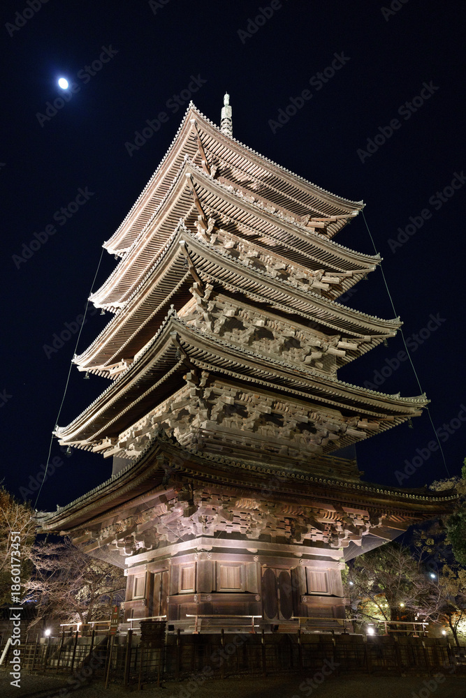 Fototapeta premium 漆黒の夜空に浮かぶ月と、幻想的にライトアップされた東寺・五重塔の静謐な夜景