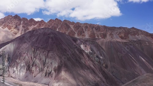 Aerial footage of picturesque wide angle Pamir multicolor and gradual light and shadow mountains valley with snow-covered peaks on background. Kyrgyzstan flying drone travel 4K video.