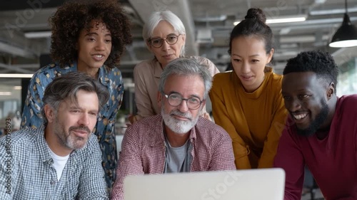 Collaboration and Innovation: A diverse group gathers around a laptop, engaged in focused collaboration and sparking innovative ideas. This image reflects a modern, inclusive workspace environment.