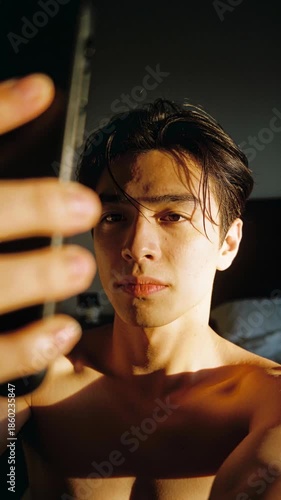 Young Man Taking a Selfie with His Phone in Warm Morning Sunlight for Social Media Lifestyle Content