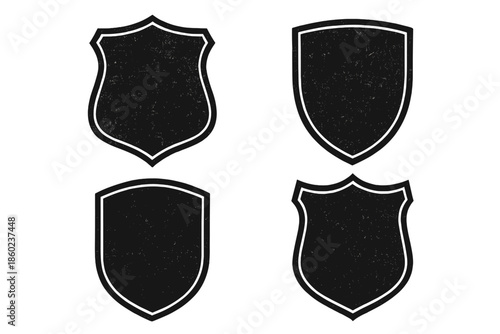 Four dark shields with textured surface on a dark background