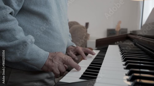 Elderly man plays piano in living room during afternoon hours