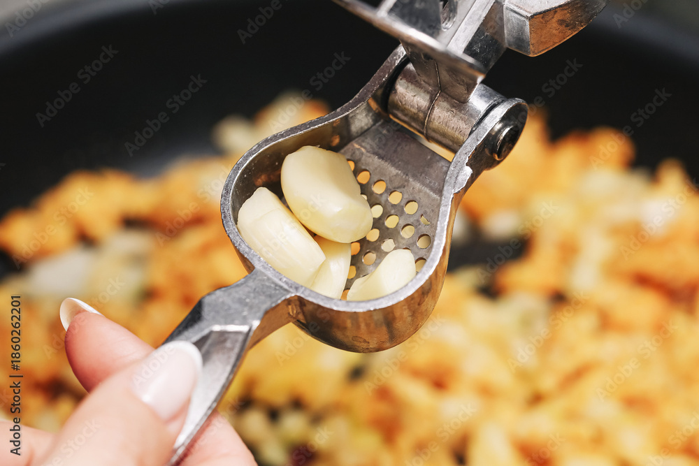 custom made wallpaper toronto digitalGarlic press closeup in kitchen. Fresh cloves inside metal tool. Cooking preparation step detail. Home food making process. Aromatic ingredient ready to use. Simple utensil in action.