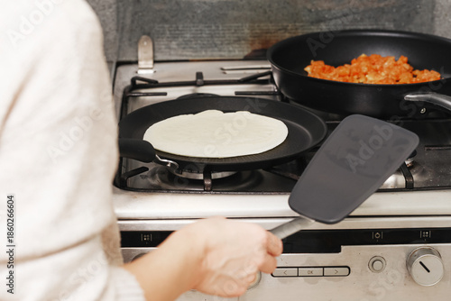Wallpaper Mural Frying crepe on kitchen stove. Chicken filling cooking in pan. Homemade dinner preparation. Simple everyday cooking process. Person turning pancake with spatula. Warm food at home kitchen. Torontodigital.ca