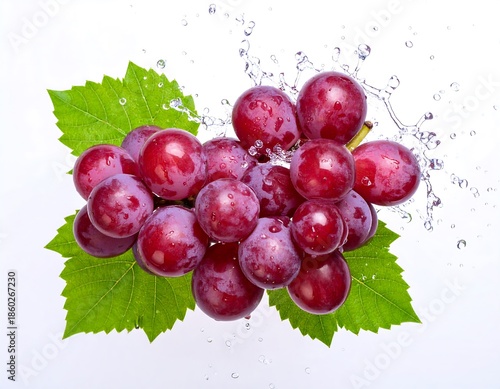 Fresh red grapes with green leaves and water splashes
