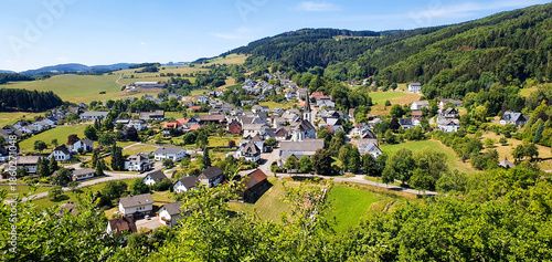 Foto Small town rolling hills landscape from view point with houses, apartments, church, nature hiking forest