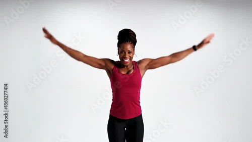 Energetic woman demonstrating jumping jack exercise for fitness and cardio training routine