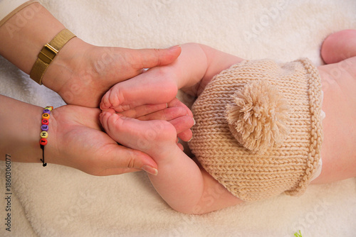 Картината върху платно Mother's hands gently cradling tiny baby feet, symbolizing warmth, care, and the