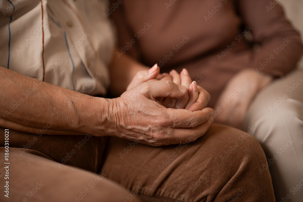 Fototapeta premium Tender Hands Holding Hands Between Elderly And Family Member In A Warm Home Setting