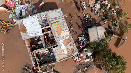 Aerial view of homes submerged in muddy floodwaters, their roofs barely visible amidst scattered debris and displaced belongings, Buzi, Sofala Province, Mozambique.