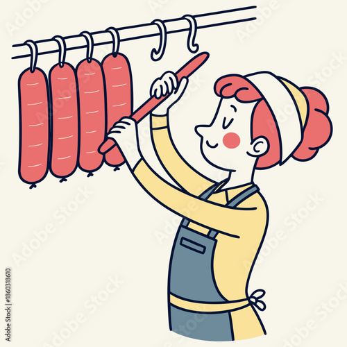 Butcher hanging sausages for processing in a workshop