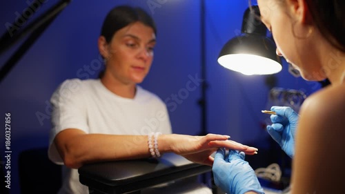 The client explains to the artist exactly what kind of coating and shape of her nails she wants. High quality 4k footage