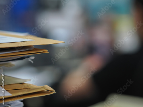Stack of documents in focus with blurred office background, paperwork concept and shallow depth of field.
