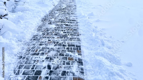 Cleared stone pavement path after snow removal, vertical view of winter maintenance result