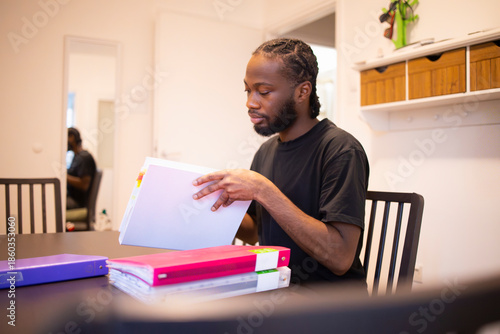 Person Studying with Binder and Folders at Table