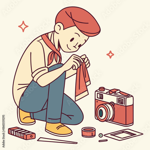 Boy cleaning a vintage camera with a cloth