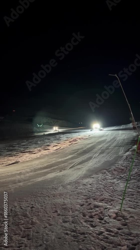 Wallpaper Mural A snowcat removes excess snow from ski slope, illuminating it spotlights Torontodigital.ca